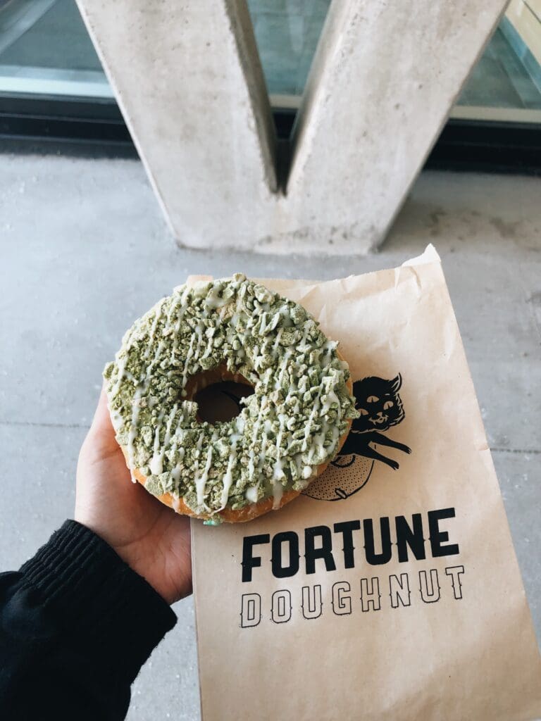 Hand holding a Matcha Kit Kat doughnut from Fortune Doughnut in Halifax's North End. 