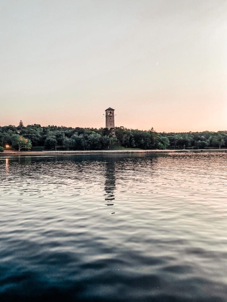 The Dingle Tower pictured at a distance across the lake in the late evening. 