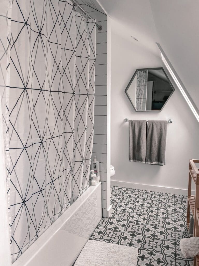 A beautifully-designed bathroom with geometric grey and white patterns throughout at this luxury staycation.