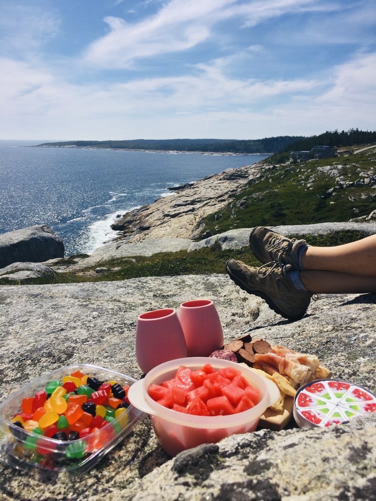 A summer picnic on a granite cliff overlooking the Atlantic ocean at a top Halifax hiking spot.