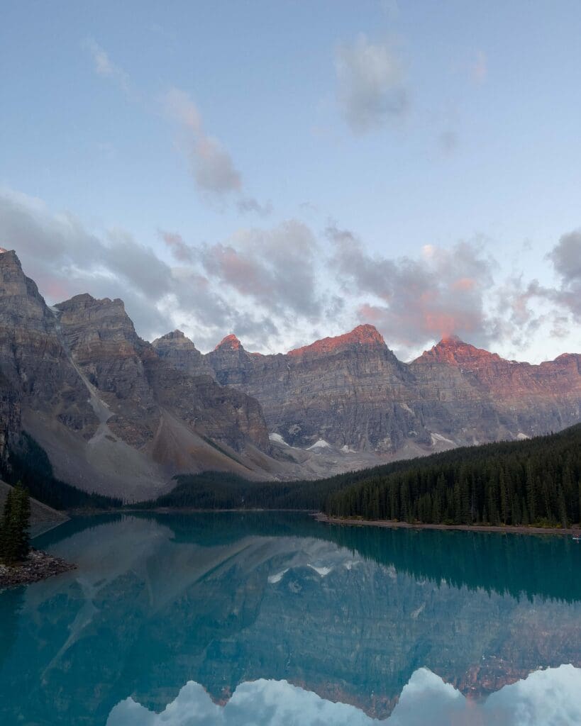 Moraine Lake at Sunrise with koolaid blue water and pink mountain tops.