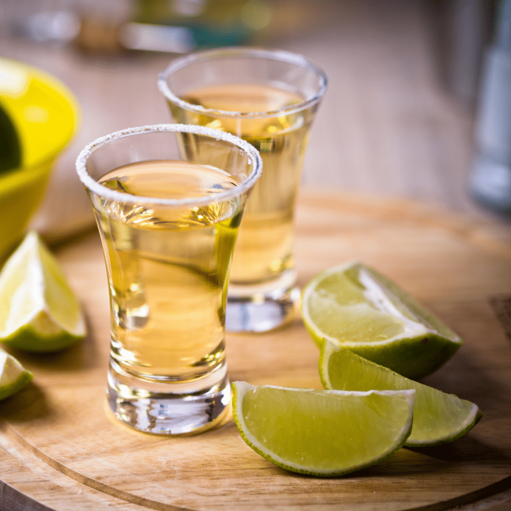 Shots of tequila with limes.