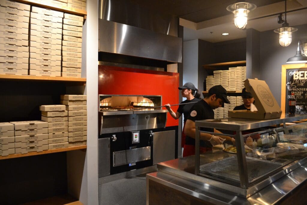 Score Pizza employees creating delicious, stone-fired pizzas.
