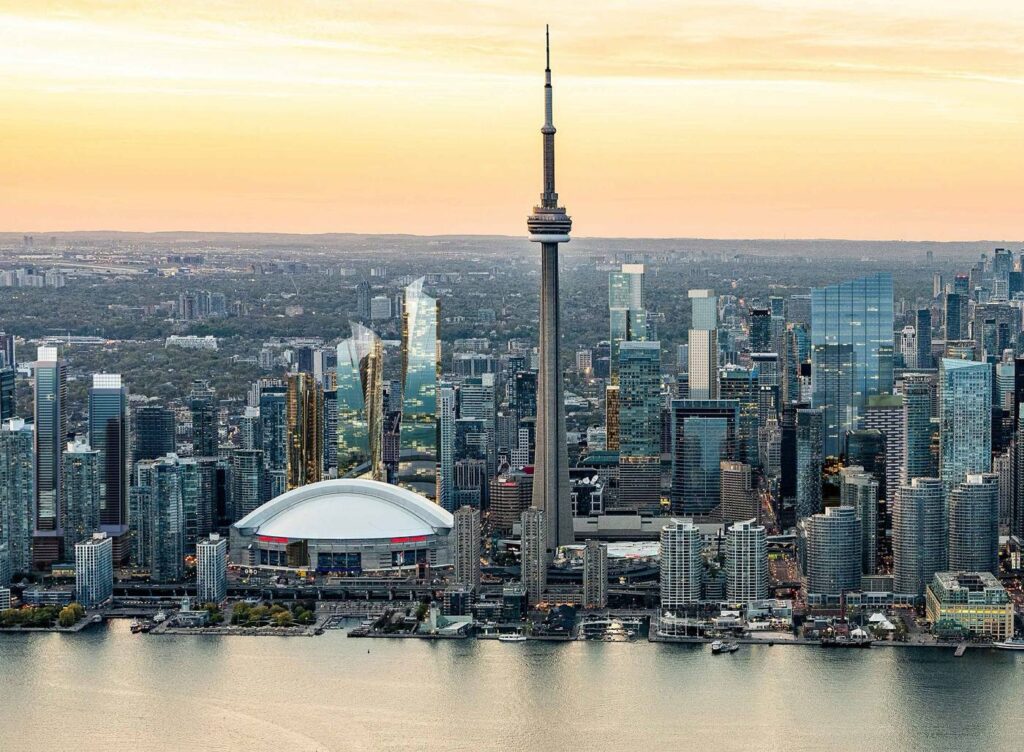 Roges stadium and the Cn Tower Toronto Skyline with a sunset backdrop.