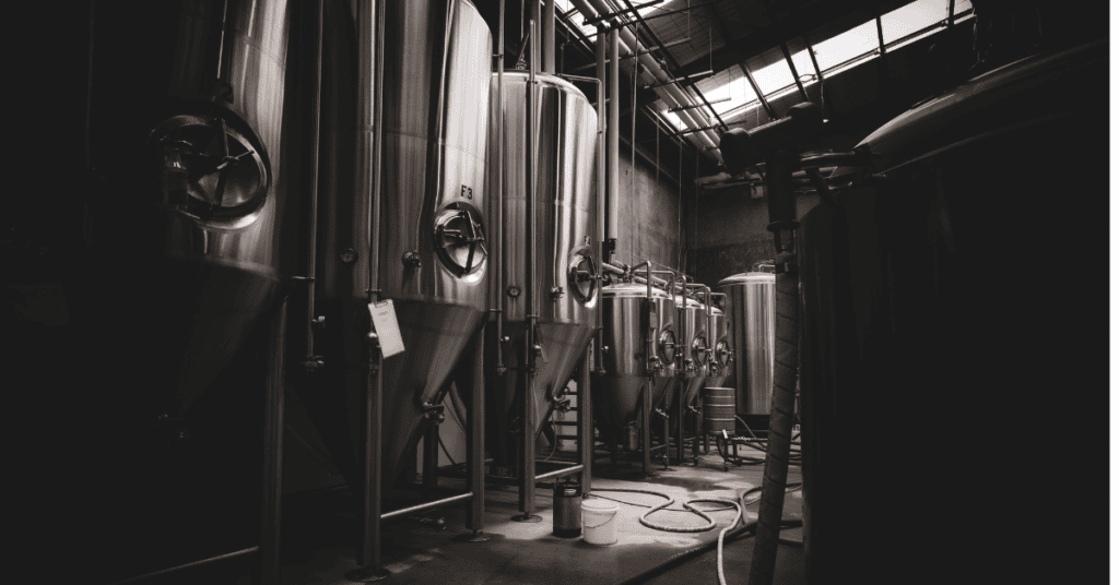 silver brewery kegs in a dark room
