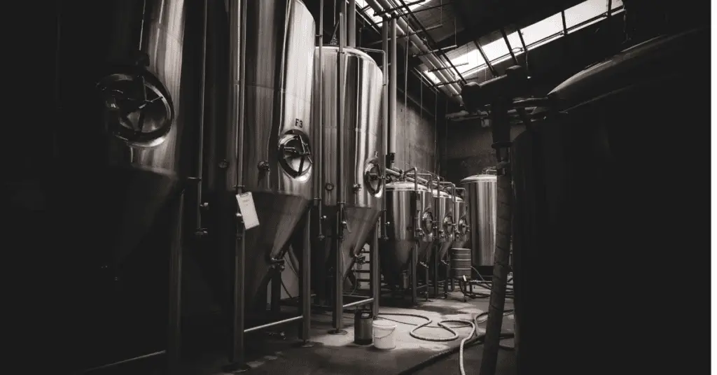 silver brewery kegs in a dark room