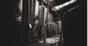 silver brewery kegs in a dark room