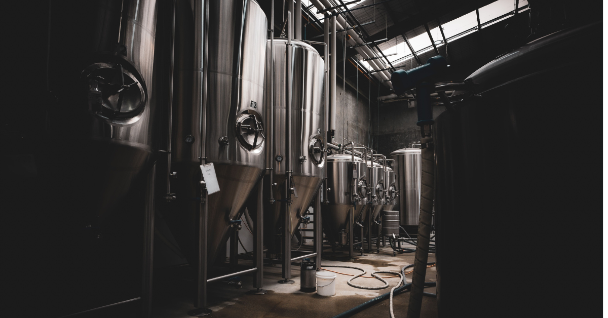 silver brewery kegs in a dark room