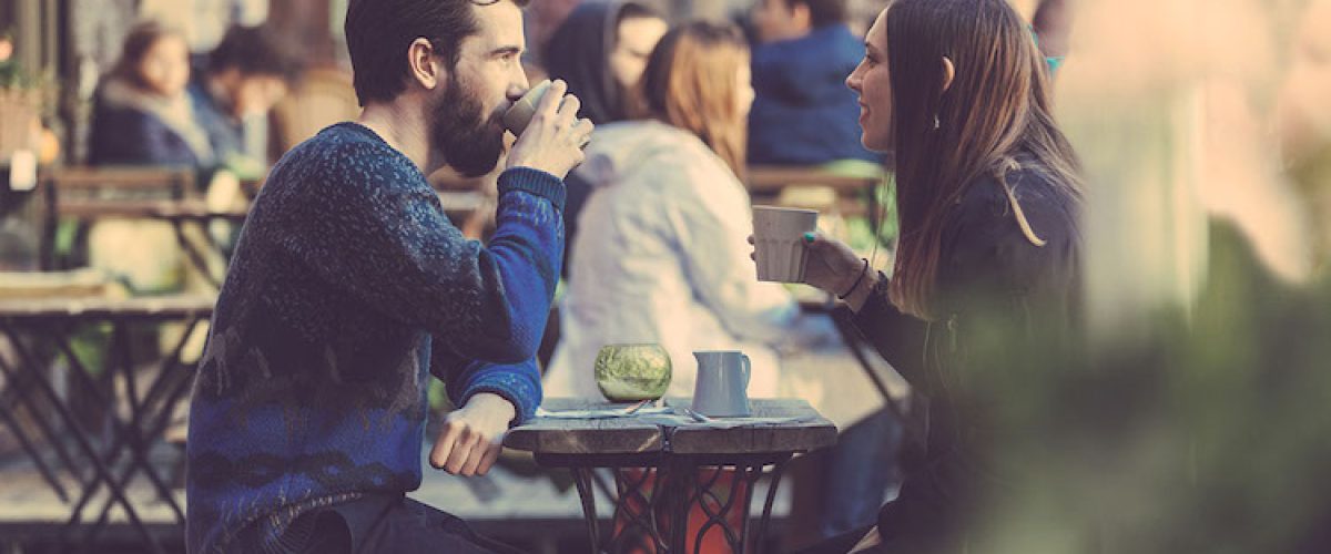A couple drinking coffee at a picnic table in Stockholm