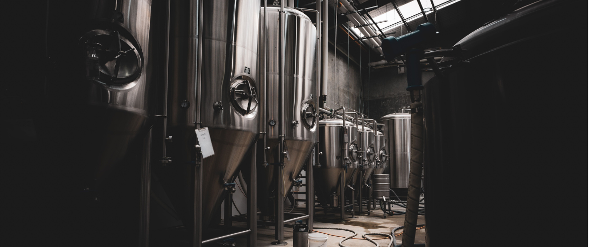 silver brewery kegs in a dark room