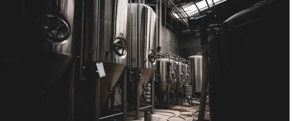 silver brewery kegs in a dark room