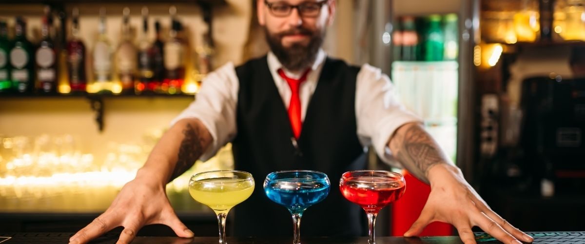 bartender presenting colourful drinks