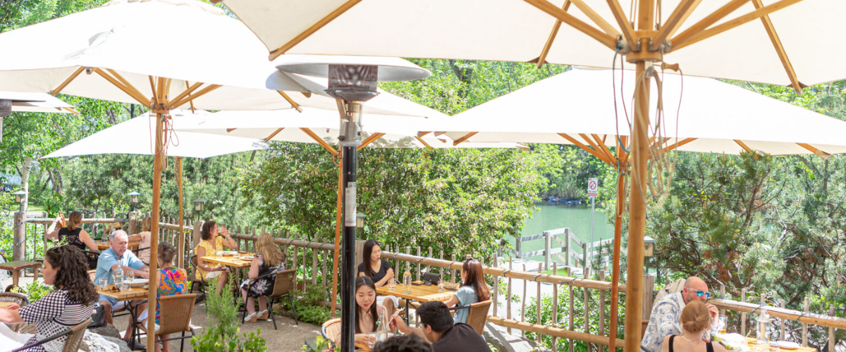 patrons enjoying a meal on a riverside cafe patio